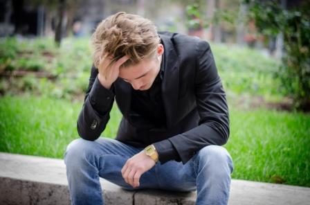 Depressed Young White Man Sitting at Street Side