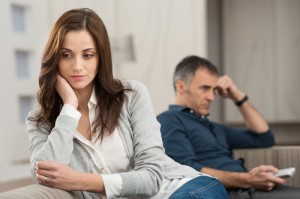 Sad Couple Sitting On Couch After Having Quarrel