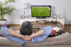 self-care and mental health - man relaxing while watching football game on TV